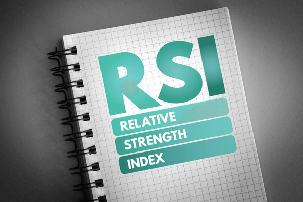 สมุดบันทึกที่มีข้อความสีเขียวคำว่า “RSI” และ “Relative Strength Index” สื่อถึงเครื่องมือวิเคราะห์ทางเทคนิค