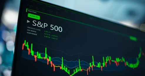 หน้าจอคอมพิวเตอร์ที่แสดงการวิเคราะห์ตลาด S&P 500 กราฟแท่งเทียนและรายงานทางการเงิน 