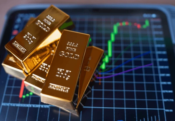 ทองคำแท่งถูกวางกองกันบนหน้าจอที่แสดงราคาทอง Forex  