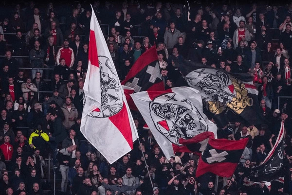 แฟนบอลของ AFC Ajax กำลังโบกธงเชียร์การแข่งขันอย่างล้นหลาน สื่อถึงความเป็นที่นิบมของทีม AFC Ajax และสามารถส่งผลต่อราคาหุ้นสโมสรฟุตบอลได้ 