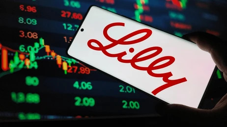 หน้าจอแสดงผลราคาหุ้น LLY พร้อมมีโทรศัพท์ที่แสดงโลโก้ของบริษัท Eli Lilly and Company 