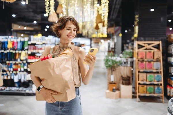 ผู้หญิงกำลังถือของใช้และอาหารที่เพิ่งซื้อเสร็จ สื่อถึงการอุปโภคบริโภคภายในประเทศที่ส่งผลถึง GDP โดยตรง 