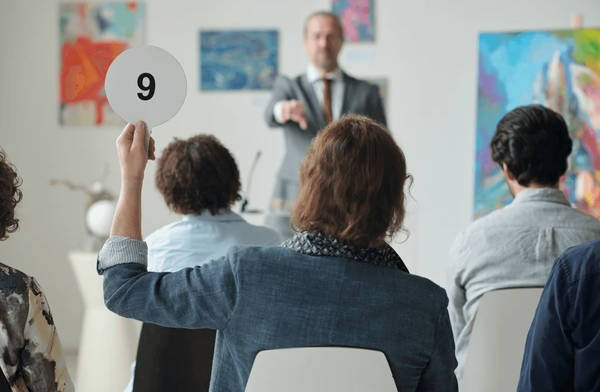 People bidding on an auction to represent an example of how to use market clearing price.